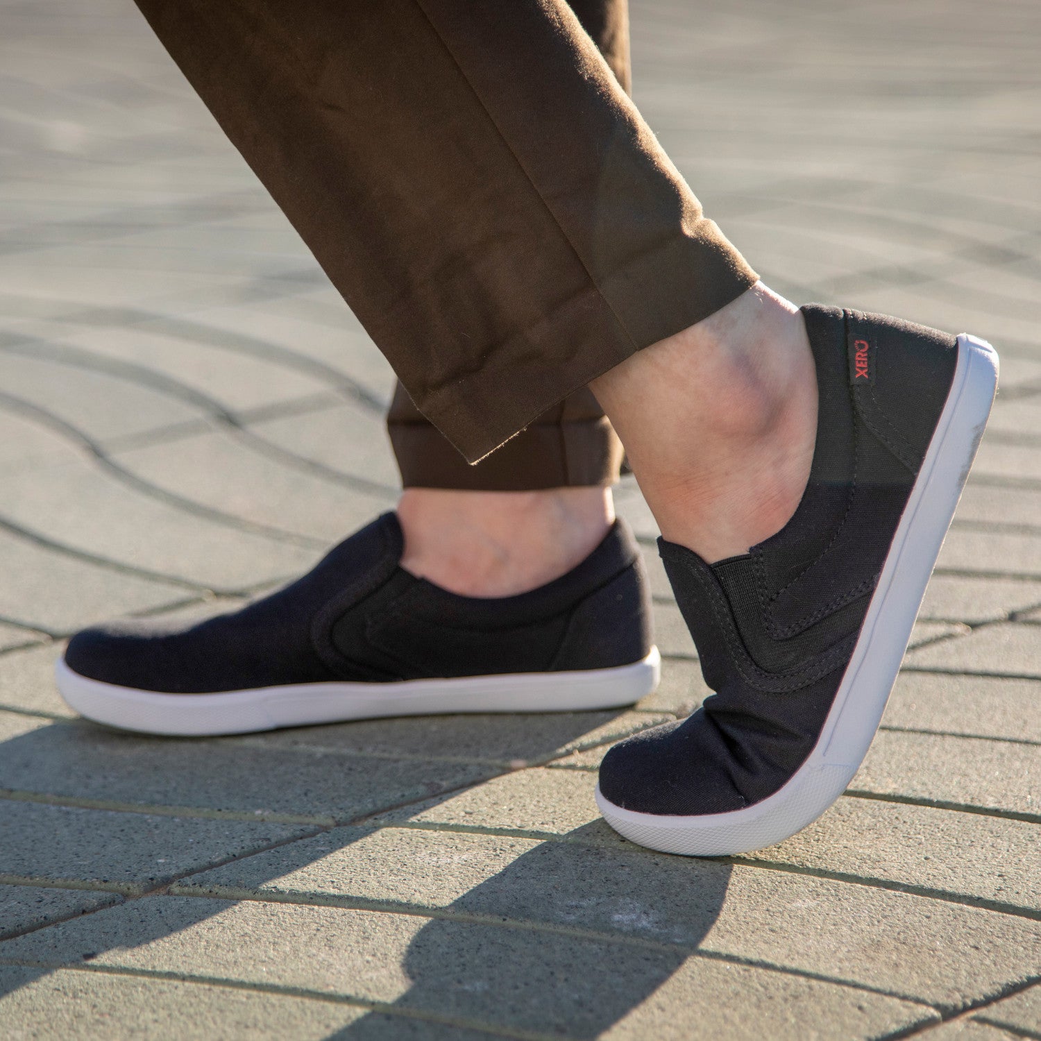 Xero Shoes Dillon Canvas Slip-On Barfußschuhe für Damen in Schwarz, gezeigt im Einsatz für Alltag und Freizeit, komfortabel und praktisch. Erhältlich in unserem Onlineshop für Barfußschuhe.