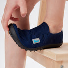 Leguanito Scio Leguano Kinder Barfußschuhe Slipper in Blau (Größen 29 bis 34) – im Alltag getragen von einem Kind, das spielerisch in einer Wiese unterwegs ist. Erhältlich im Barfußschuhe Onlineshop barfusswelteb.com.